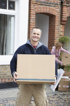 Removal team packing and loading household items into a vehicle